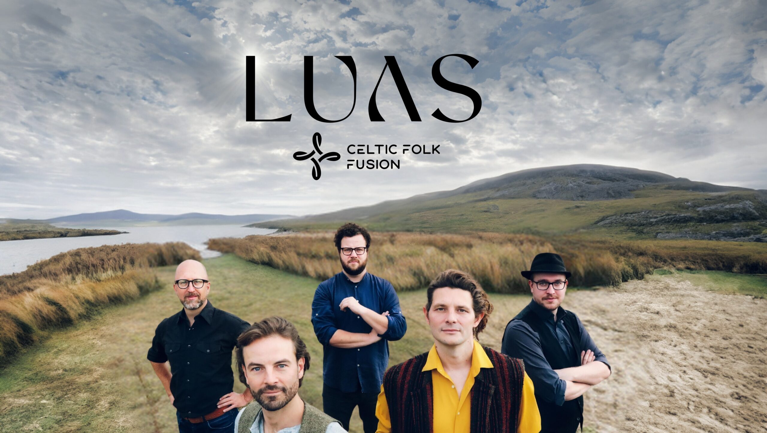 five celtic musicians posing in front of stunning scottish landscape